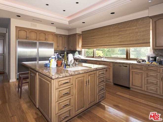 Sự kết hợp giữa chất liệu gỗ - đá hoa cương và các thiết bị nấu nướng cao cấp mang đến vẻ đẹp sang trọng cho phòng bếp. Cửa sổ cao rộng giúp không gian luôn thoáng sáng.
